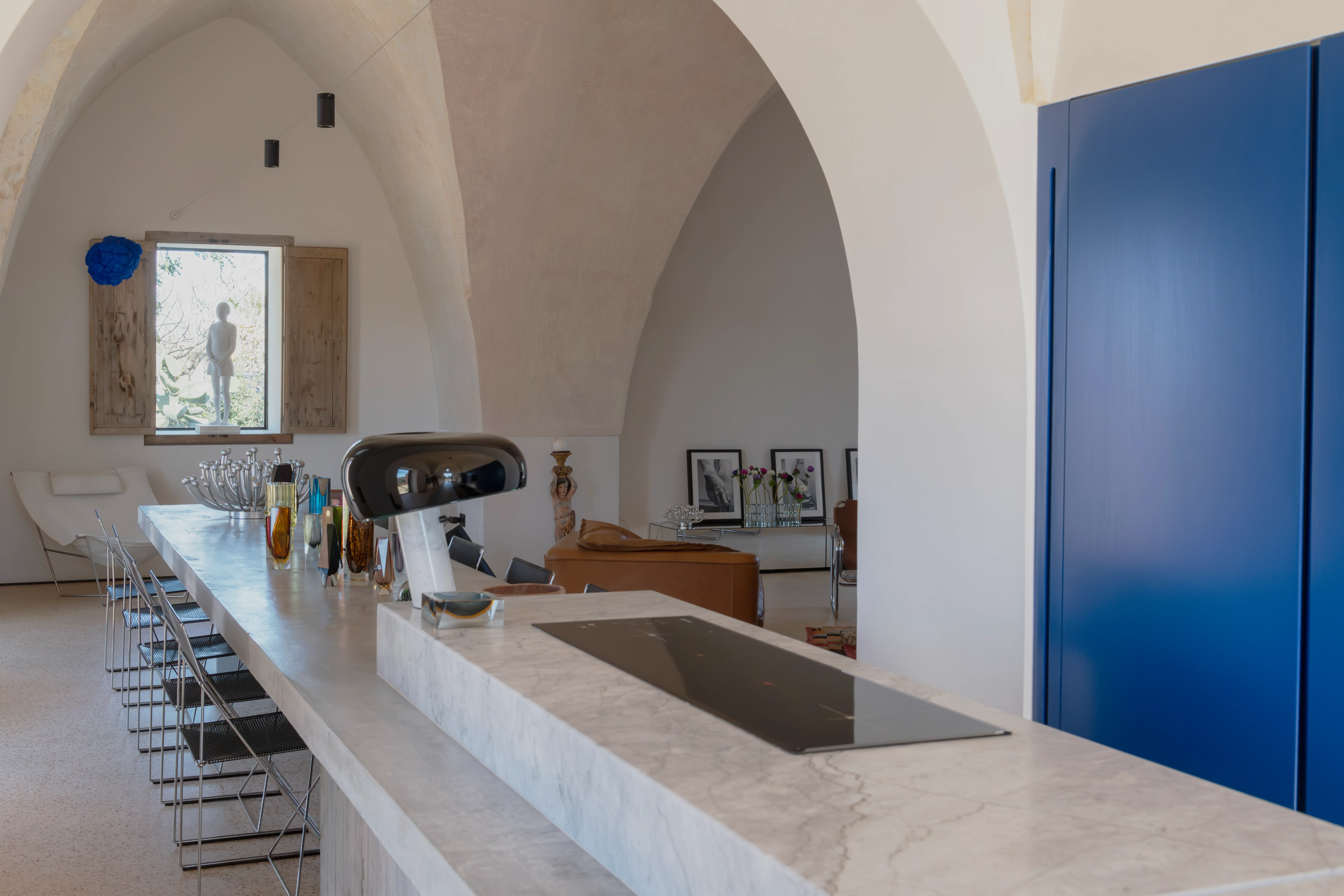 Cucina di Casa Rosa con parete blu Klein, camino antico e isola centrale
